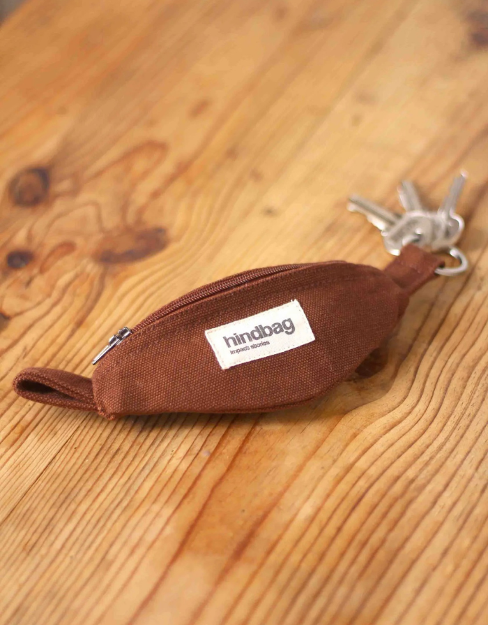 Hindbag Côme Schlüsselanhänger Schoko – getragen an Tasche, kompaktes Mini-Bauchtaschen-Design