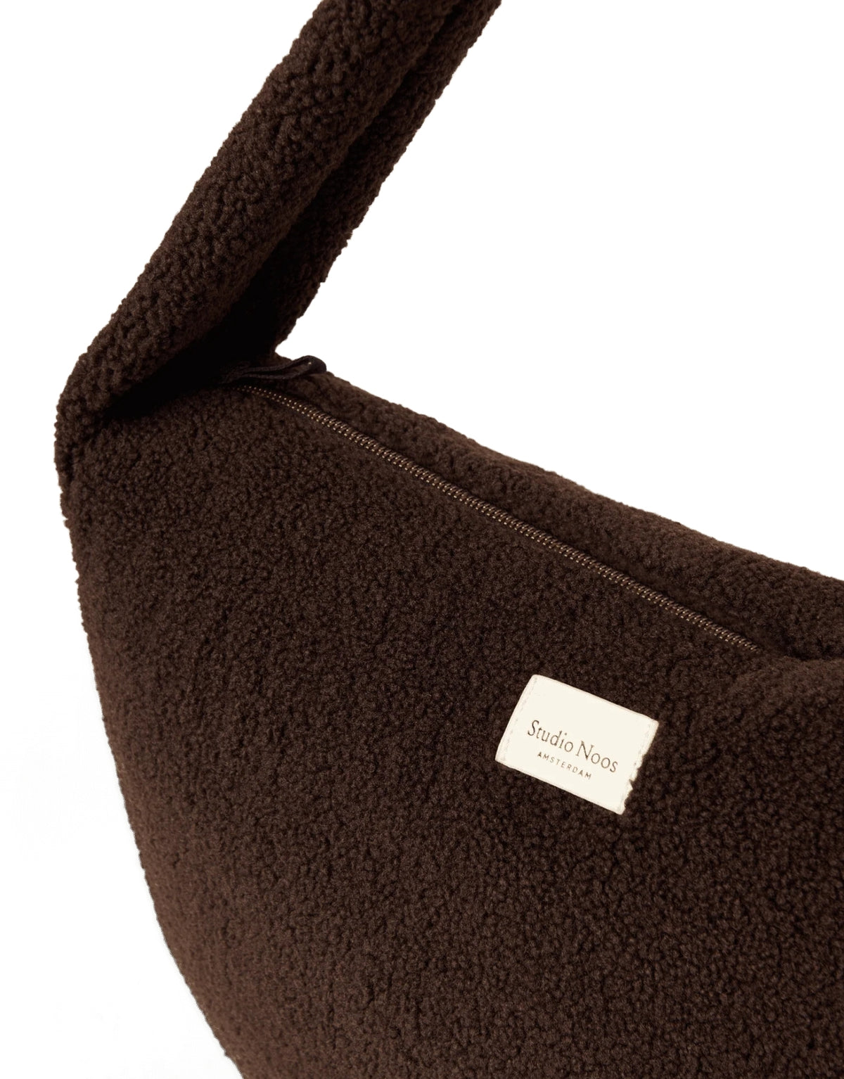 Schokoladenbraune Cross Body Umhängetasche Chocolate Teddy von Studio Noos aus weichem Teddy-Material mit Seitentaschen und Platz für einen 13-Zoll-Laptop.