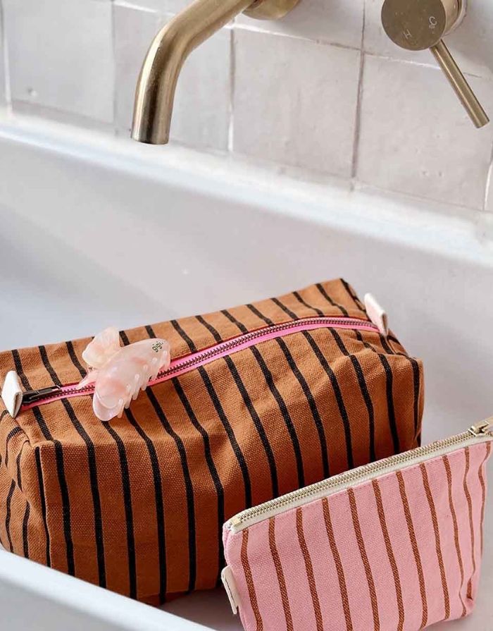 Kosmetiktasche Sofia von Rose in April in Rosa mit braunen Streifen neben einer anderen Kosmetiktasche