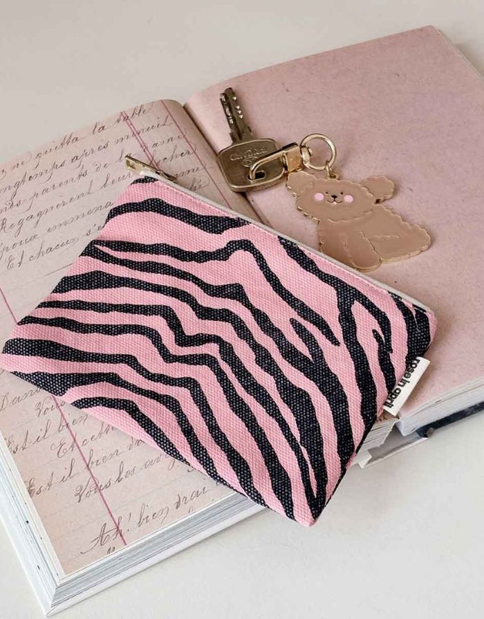 Kleine Tasche für Kosmetik oder Geld von Rose in April in Rosa mit schwarzem Zebra Muster auf einem Notizbuch