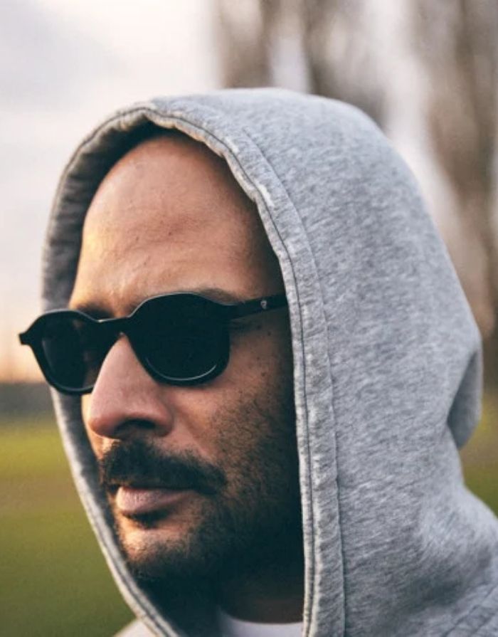 Schwarze CHPO Sonnenbrille mit glänzendem Gestell, schwarzen Gläsern, UV400-Schutz und Gestell aus recyceltem Kunststoff am Model.