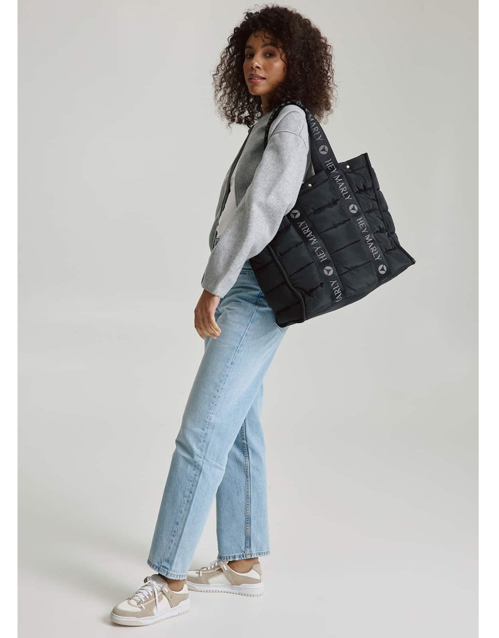 Große Hey Marly Best Buddy Tasche in Schwarz aus weichem, leichtem Material mit Signature-Henkeln und geräumigem Innenfach am Model von der Seite