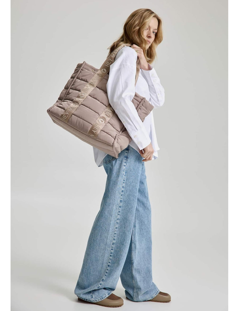 Große Hey Marly Best Buddy Tasche in Mocha aus weichem, leichtem Material mit Signature-Henkeln und geräumigem Innenfach am Model von der Seite