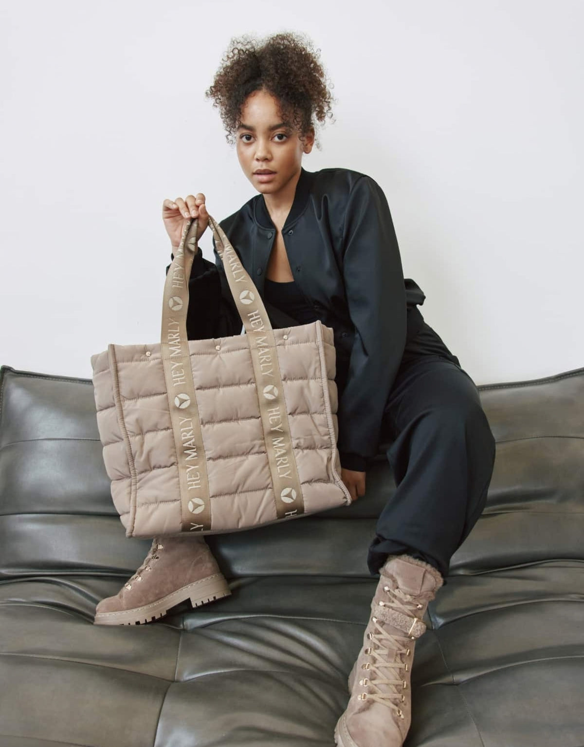 Große Hey Marly Best Buddy Tasche in Mocha aus weichem, leichtem Material mit Signature-Henkeln und geräumigem Innenfach am Model in der Hand