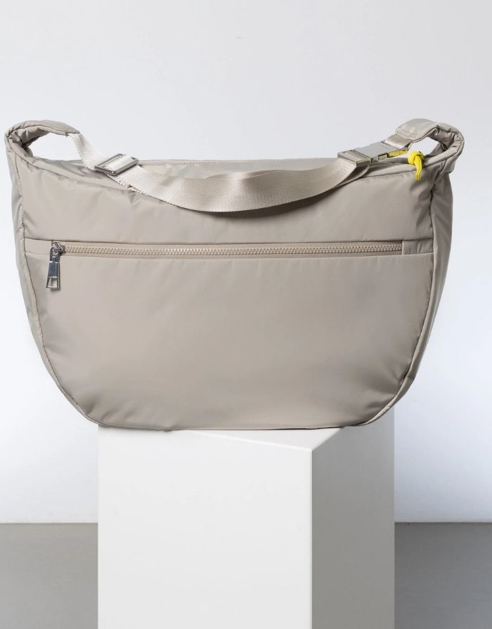 Padded Hip Bag Oversized von Vivi Mari in Stone, große wasserabweisende Umhängetasche mit zwei Außentaschen, verstellbarem Schultergurt und silbernen Metallakzenten, aus recyceltem Polyester.