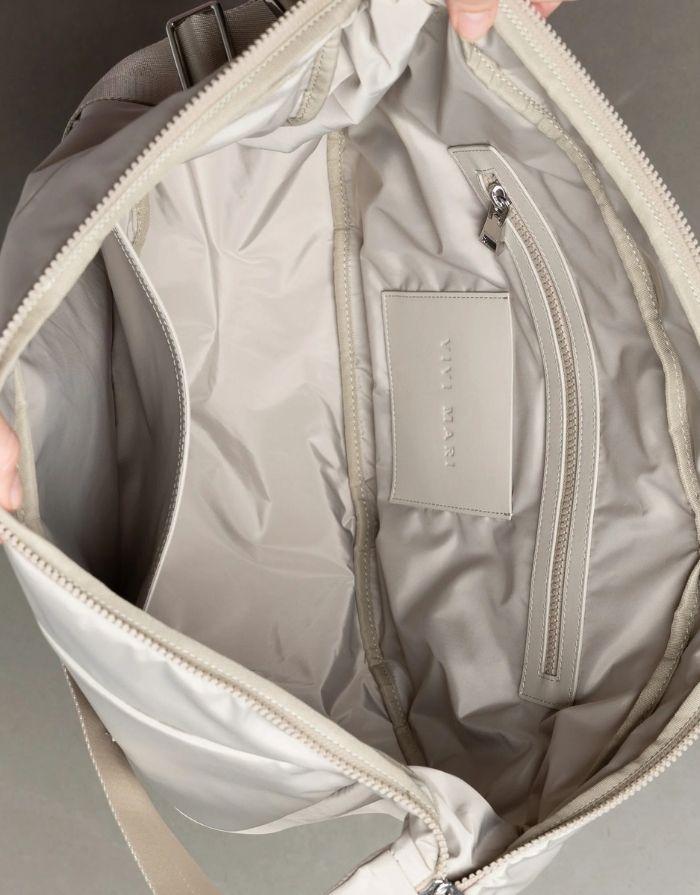 Padded Hip Bag Oversized von Vivi Mari in Stone, große wasserabweisende Umhängetasche mit zwei Außentaschen, verstellbarem Schultergurt und silbernen Metallakzenten, aus recyceltem Polyester.