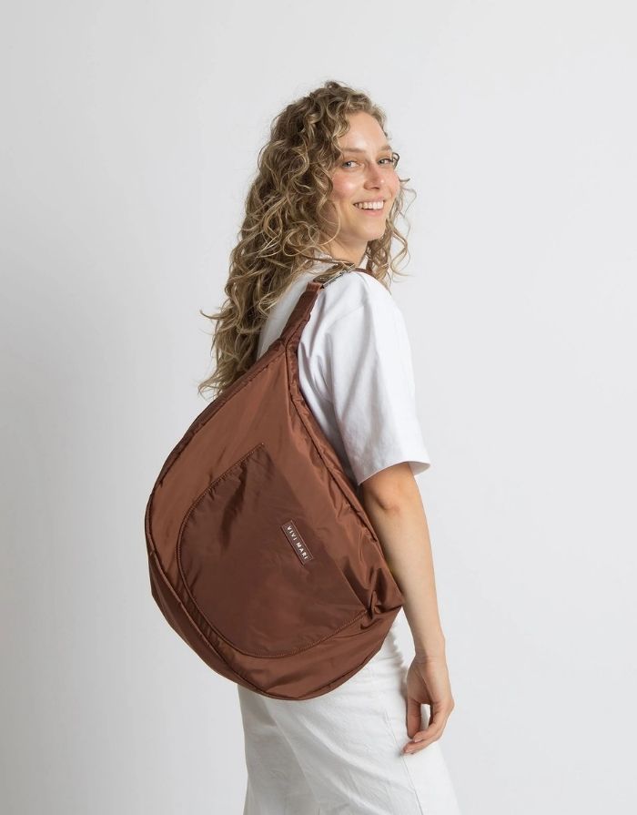 Padded Hip Bag Oversized von Vivi Mari in Tan, große wasserabweisende Umhängetasche mit zwei Außentaschen, verstellbarem Schultergurt und silbernen Metallakzenten, aus recyceltem Polyester.