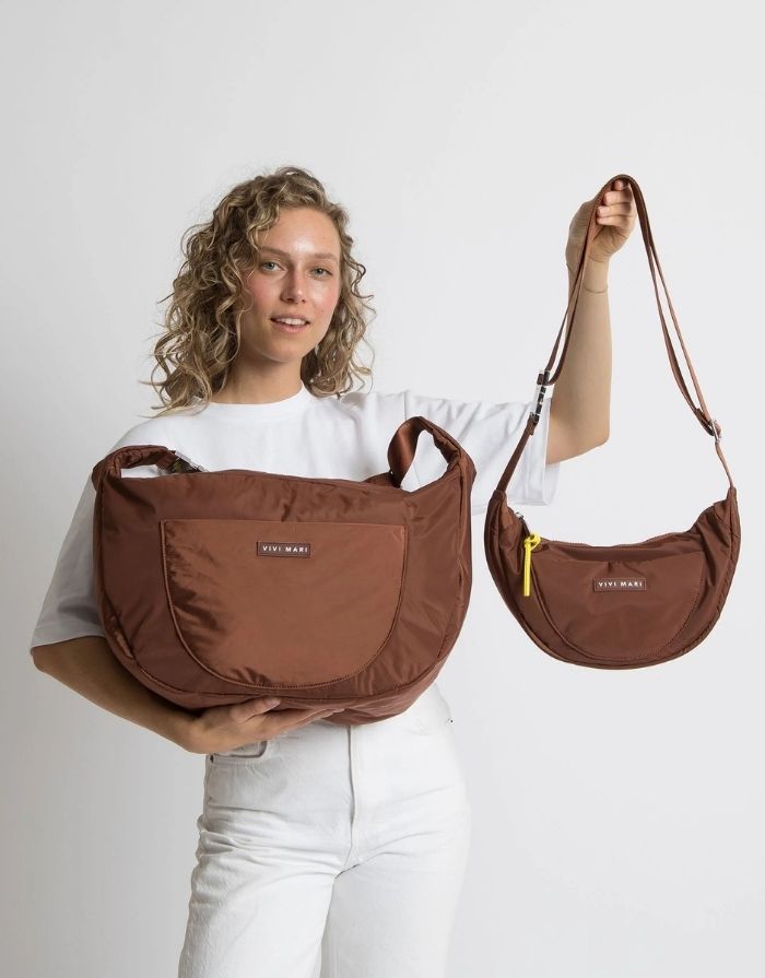 Padded Hip Bag Oversized von Vivi Mari in Tan, große wasserabweisende Umhängetasche mit zwei Außentaschen, verstellbarem Schultergurt und silbernen Metallakzenten, aus recyceltem Polyester.