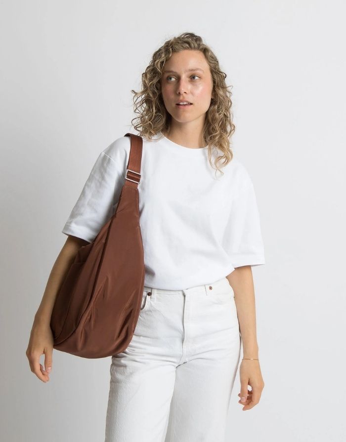 Padded Hip Bag Oversized von Vivi Mari in Tan, große wasserabweisende Umhängetasche mit zwei Außentaschen, verstellbarem Schultergurt und silbernen Metallakzenten, aus recyceltem Polyester.