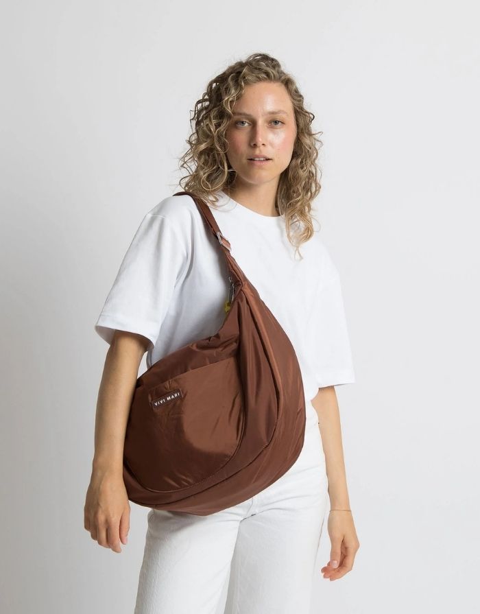 Padded Hip Bag Oversized von Vivi Mari in Tan, große wasserabweisende Umhängetasche mit zwei Außentaschen, verstellbarem Schultergurt und silbernen Metallakzenten, aus recyceltem Polyester.