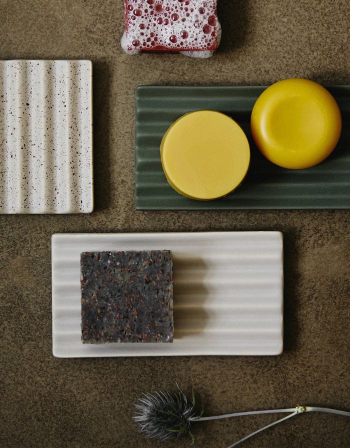 Nordal Keramik Seifenschale in Terrazzo-Optik mit Rillen zum Trocknen von Seife mit einer dunklen quadratischen seife von nordal darauf