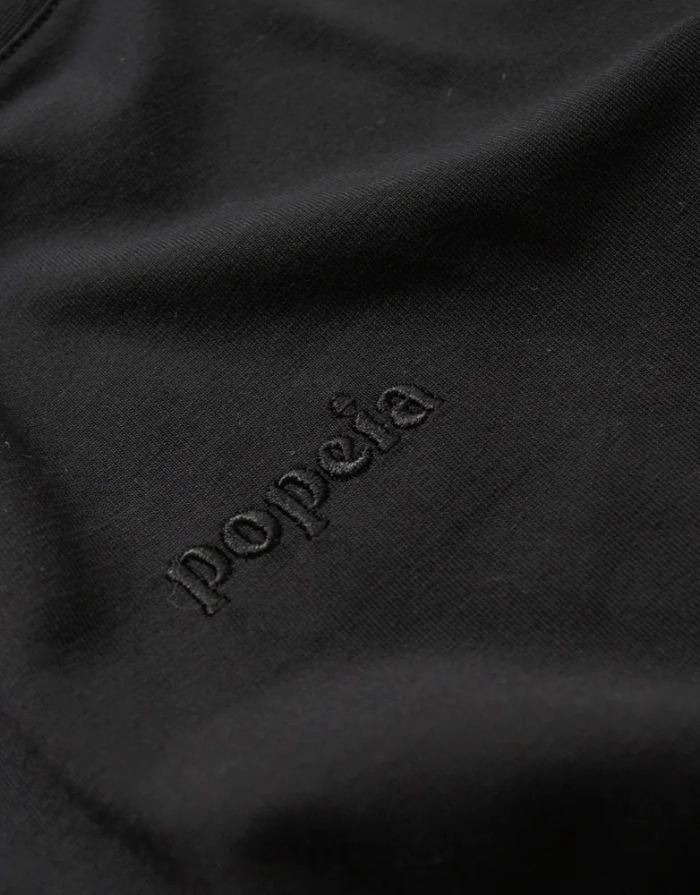 Schwarzes Langarmshirt von Popeia aus 100 % Bio-Baumwolle mit Relaxed Fit, breitem Kragen und Kindness-Spruch im Nacken.