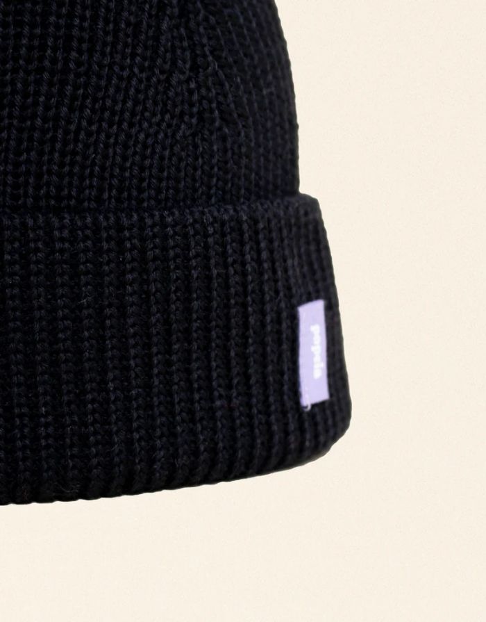 Schwarze Beanie aus weicher Merinowolle, gefaltet, schlichtes Design, gemütlich und stylisch für den Winter