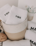 Weiße Babysocken Mini von Eulenschnitt mit schwarzem Schriftzug für Babys im Alter von 3 Monaten