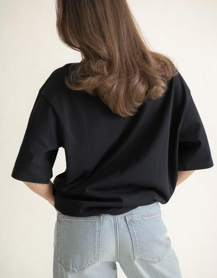 Schwarzes Oversize T-Shirt von Gina Tricot mit langer Passform, kurzen Ärmeln und Rundhalsausschnitt.
