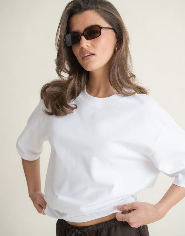 Weißes Oversize T-Shirt von Gina Tricot mit langer Passform, kurzen Ärmeln und Rundhalsausschnitt.
