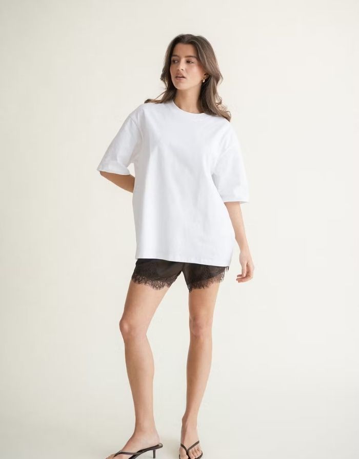Weißes Oversize T-Shirt von Gina Tricot mit langer Passform, kurzen Ärmeln und Rundhalsausschnitt.
