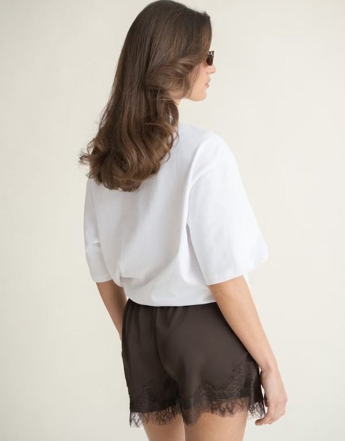 Weißes Oversize T-Shirt von Gina Tricot mit langer Passform, kurzen Ärmeln und Rundhalsausschnitt.
