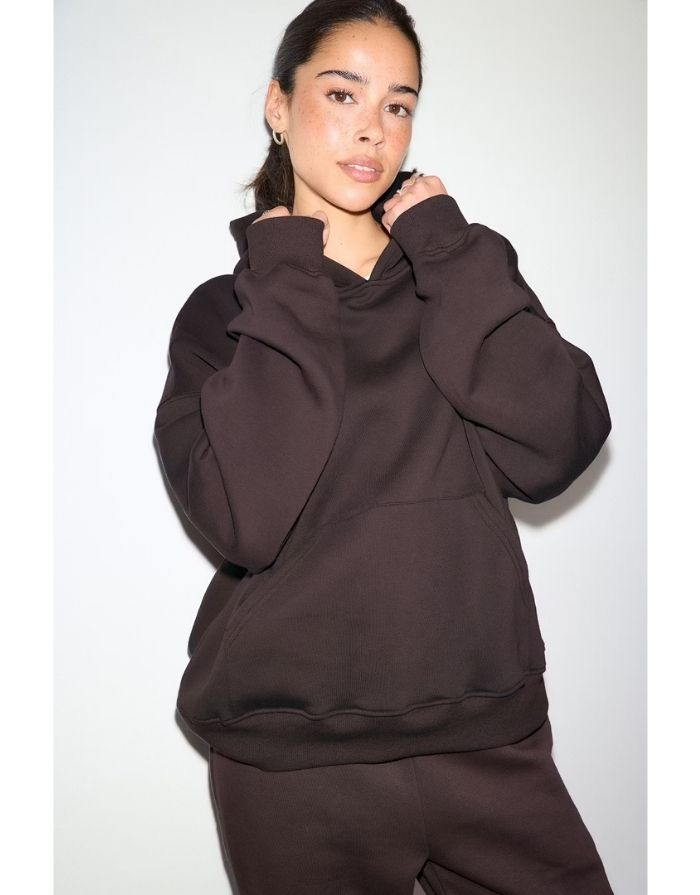 Gina Tricot Iconic Hoodie in Chocolate Plum mit Oversize-Passform, Kängurutasche und gefütterter Kapuze am Model von vorne