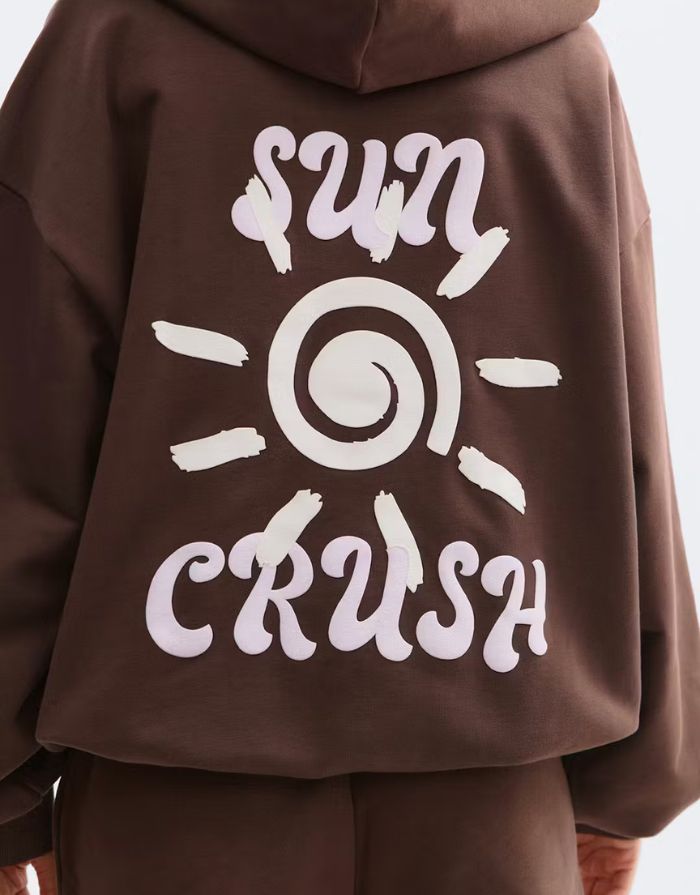 Brauner Hoodie von Gina Tricot mit lockerem Schnitt und Textprint auf dem Rücken.