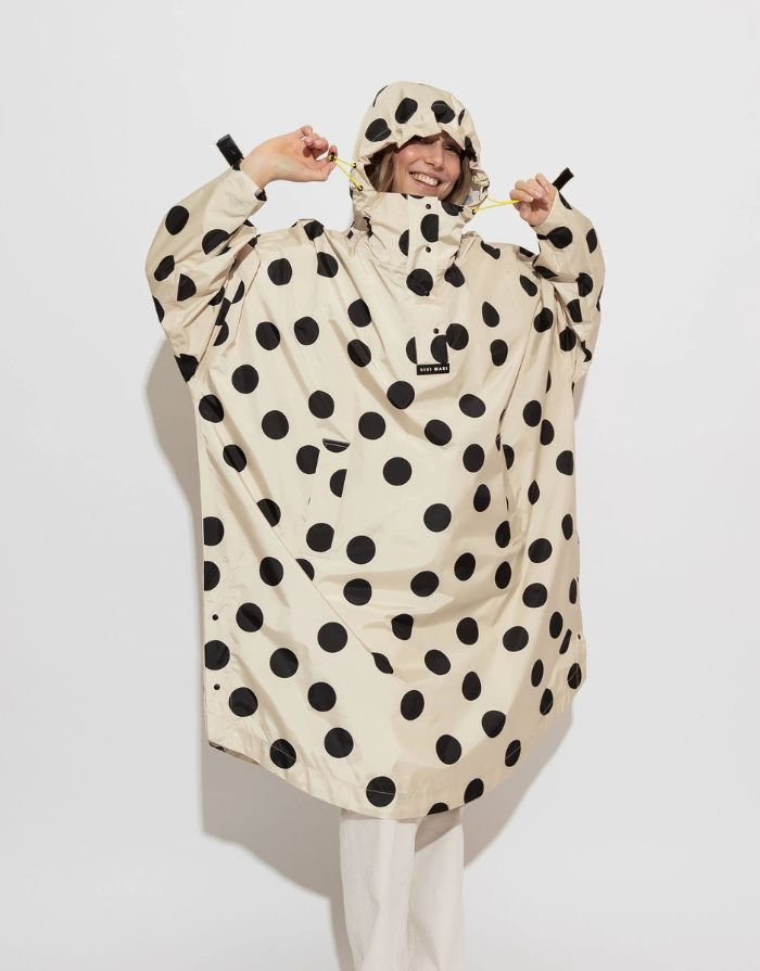 Raincoat Bold Stripes Dots Black/Sand von VIVI MARI: Langer, wasserdichter Regenmantel im Streifen-Design, oversized geschnitten mit Kapuze, Knopfleiste, Klettverschluss-Manschetten und praktischen Taschen – nachhaltig aus recyceltem Polyester gefertigt.