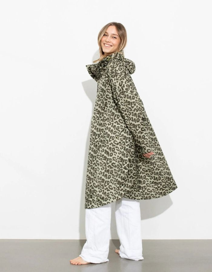Raincoat Leo Splashes Navy Oliv von VIVI MARI: Langer, wasserdichter Regenmantel im Streifen-Design, oversized geschnitten mit Kapuze, Knopfleiste, Klettverschluss-Manschetten und praktischen Taschen – nachhaltig aus recyceltem Polyester gefertigt.