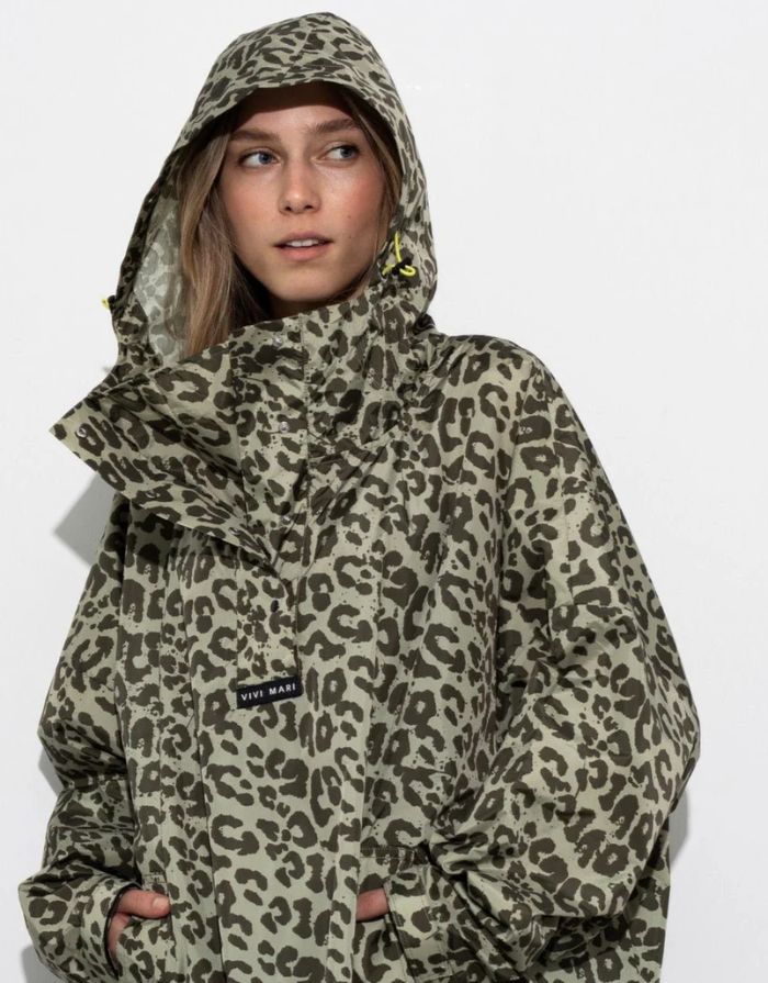Raincoat Leo Splashes Navy Oliv von VIVI MARI: Langer, wasserdichter Regenmantel im Streifen-Design, oversized geschnitten mit Kapuze, Knopfleiste, Klettverschluss-Manschetten und praktischen Taschen – nachhaltig aus recyceltem Polyester gefertigt.