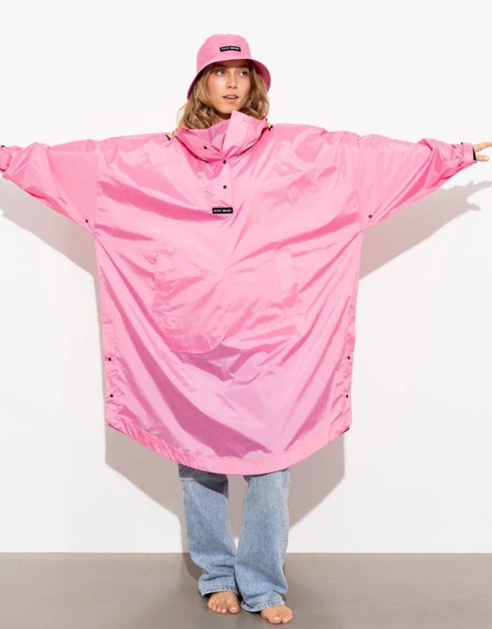 Raincoat Bold Stripes Soft Pink von VIVI MARI: Langer, wasserdichter Regenmantel im Streifen-Design, oversized geschnitten mit Kapuze, Knopfleiste, Klettverschluss-Manschetten und praktischen Taschen – nachhaltig aus recyceltem Polyester gefertigt.