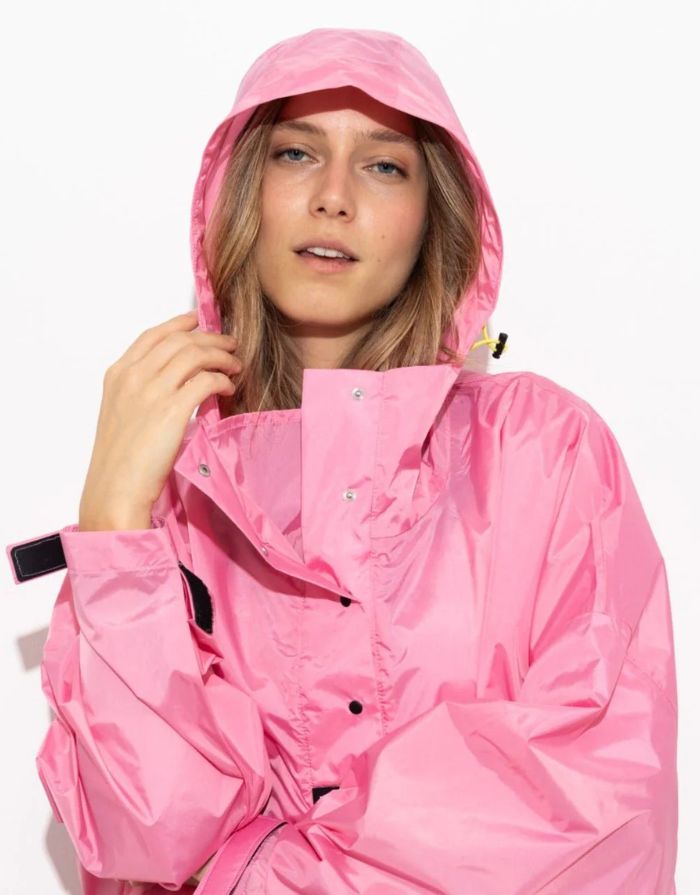 Raincoat Bold Stripes Soft Pink von VIVI MARI: Langer, wasserdichter Regenmantel im Streifen-Design, oversized geschnitten mit Kapuze, Knopfleiste, Klettverschluss-Manschetten und praktischen Taschen – nachhaltig aus recyceltem Polyester gefertigt.