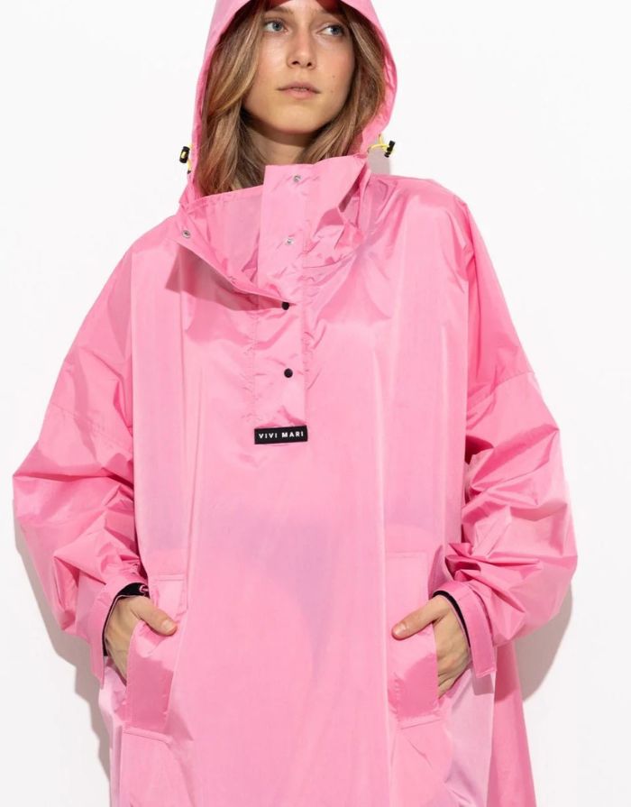 Raincoat Bold Stripes Soft Pink von VIVI MARI: Langer, wasserdichter Regenmantel im Streifen-Design, oversized geschnitten mit Kapuze, Knopfleiste, Klettverschluss-Manschetten und praktischen Taschen – nachhaltig aus recyceltem Polyester gefertigt.
