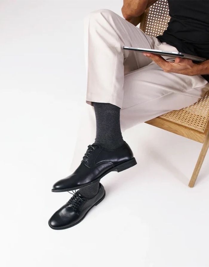 Schwarze Business-Socken von Snocks aus Bio-Baumwolle mit komfortabler Passform und knielanger Form für den Büroalltag am Model mit Schuh