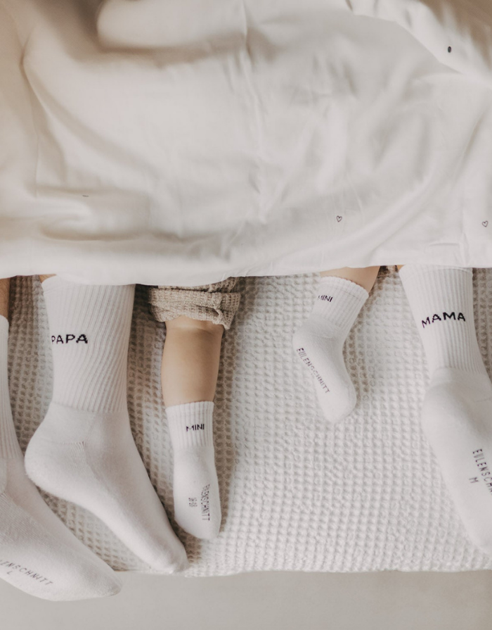 Weiße Socken Mama von Eulenschnitt mit schwarzem Schriftzug und schwarzen Details