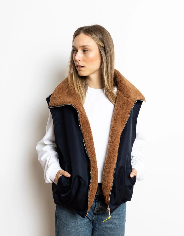 Reversible Bomber Weste von Vivi Mari in Navy und Karamell, tragbar mit glattem Nylon oder weichem Fleece außen, oversized geschnitten mit Reißverschluss und Taschen, ideal für Layering und urbane Looks.