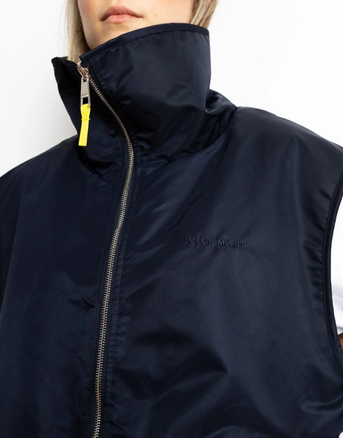Reversible Bomber Weste von Vivi Mari in Navy und Karamell, tragbar mit glattem Nylon oder weichem Fleece außen, oversized geschnitten mit Reißverschluss und Taschen, ideal für Layering und urbane Looks.