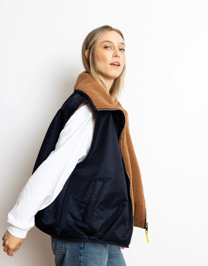 Reversible Bomber Weste von Vivi Mari in Navy und Karamell, tragbar mit glattem Nylon oder weichem Fleece außen, oversized geschnitten mit Reißverschluss und Taschen, ideal für Layering und urbane Looks.
