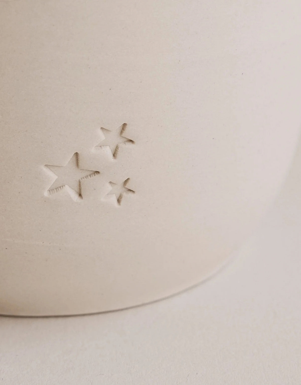 Handgefertigter Steingutbecher Sterne von Eulenschnitt mit eingeprägten Sternen Motiv und einem Fassungsvermögen von ca. 320 ml im Detail 