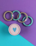 Ava & Yves Haargummi-Set Flieder/Blau – 4 elastische Haargummis mit Schimmer in runder Geschenkbox.
