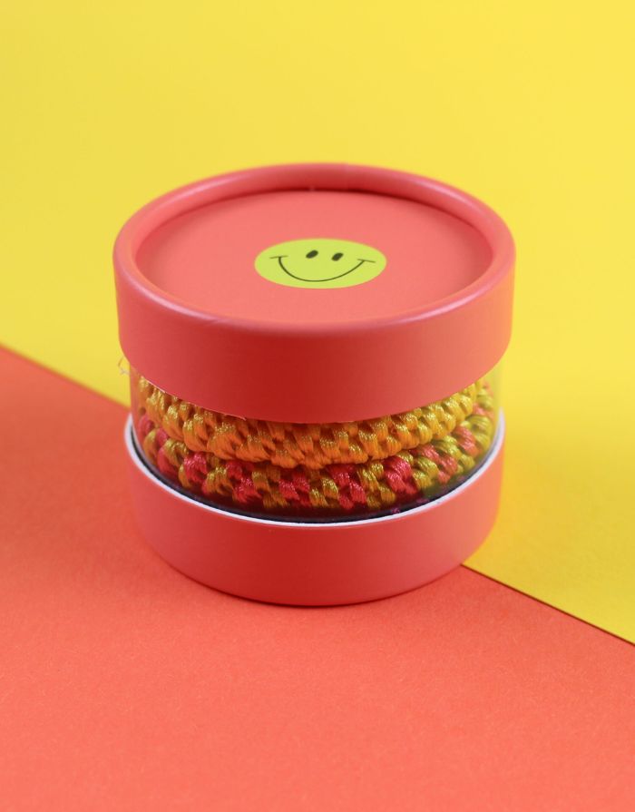 Ava & Yves Haargummi-Set Koralle/Gelb – 4 elastische Haargummis in runder Geschenkbox mit Smiley.