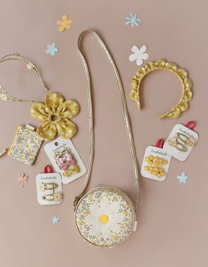 Daisy Daisy Haarspangen von Rockahula mit Gänseblumen auf goldglitzernden, stoffbezogenen Klickspangen.