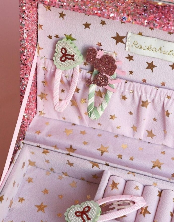 Sweet Heart Bow Haarspangen von Rockahula mit Herzmotiven, glitzernden roten Schleifen und rosafarbenen, stoffbezogenen Klickspangen.
