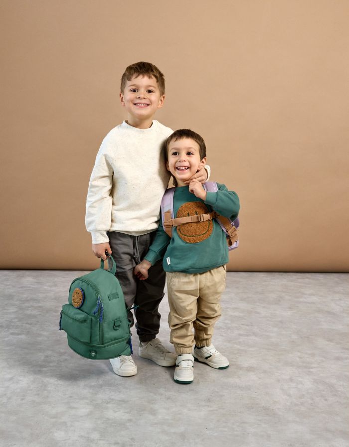 Kinderrucksack Mini Little Gang von Lässig in Dunkelgrün mit farbenfrohem Patch, Netztasche, Frontfach und separatem Nassfach – nachhaltig aus recyceltem Polyester gefertigt.
