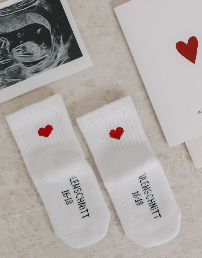 Babysocken Herz Rot von Eulenschnitt, 80% Baumwolle, 18% Polyamid, 2% Elastan, mit eingesticktem roten Herz auf dem Bündchen.