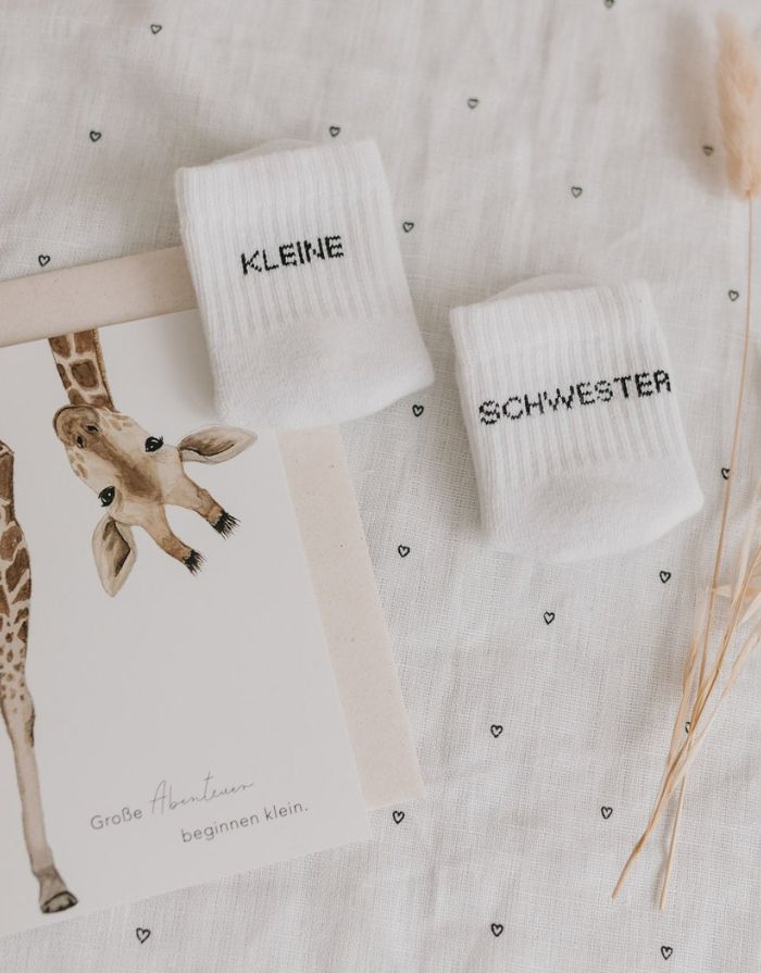 Babysocken Kleine Schwester von Eulenschnitt, 80% Baumwolle, 18% Polyamid, 2% Elastan, mit Schriftzug „Kleine Schwester“ auf dem Bündchen.