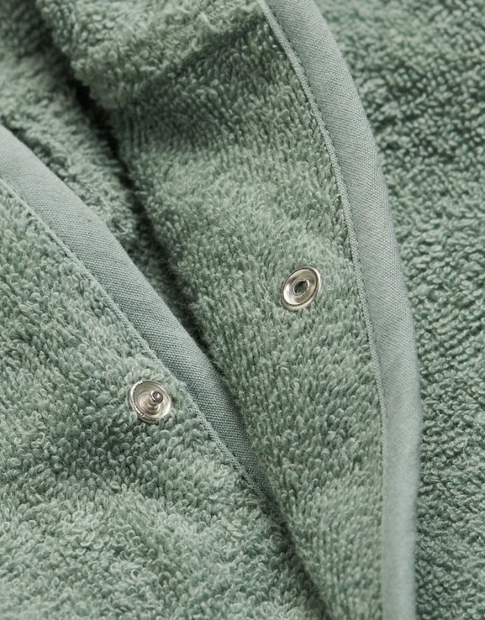 Jollein Kinderbademantel in der Farbe Ash Green aus weichem Baumwollfrottee mit Kapuze und Gürtel.