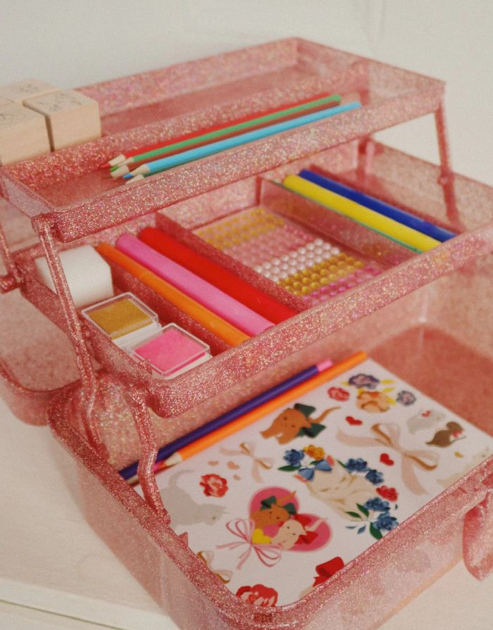 Glitzernder Bastelkoffer in Rosa von Konges Sløjd, gefüllt mit Stiften, Stickern, Stempeln, einem Notizblock und einem kleinen Malbuch – kreatives Set für Kinder.