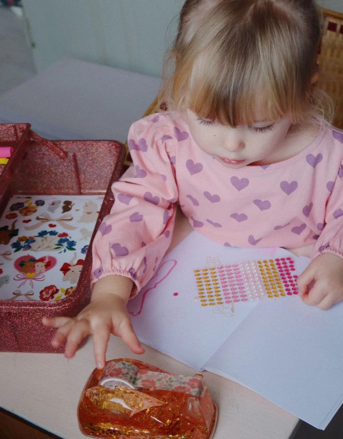 Glitzernder Bastelkoffer in Rosa von Konges Sløjd, gefüllt mit Stiften, Stickern, Stempeln, einem Notizblock und einem kleinen Malbuch – kreatives Set für Kinder.