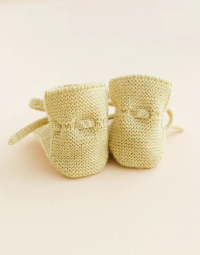 Weiche Hvid Original Booties aus extrafeiner Merinowolle mit Schnürbändern für sicheren Halt an kleinen Babyfüßen in hellem Gelb von hinten