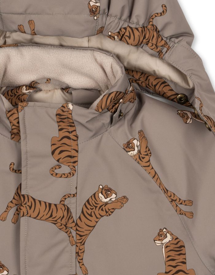 Hellbrauner Schneeeinteiler mit Tigermuster von Konges Sløjd, wasser- und winddicht, mit abnehmbarer Kapuze und Handschuhhaken.