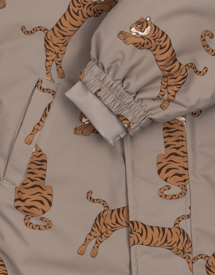 Hellbrauner Schneeeinteiler mit Tigermuster von Konges Sløjd, wasser- und winddicht, mit abnehmbarer Kapuze und Handschuhhaken.