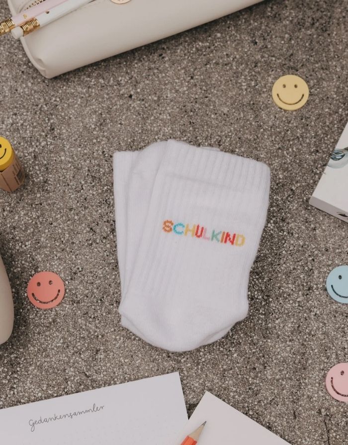 Weiße Eulenschnitt Socken „Schulkind“ mit buntem Schriftzug auf der Ferse und weichen Bündchen für Kinder